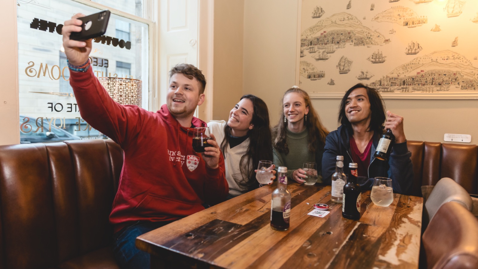 Four students taking a selfie in a local pub.